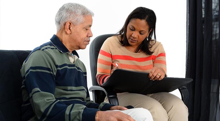 counseling session-senior man with female taking notes